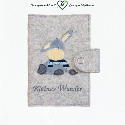 Mutter-Kind-Pass Hülle hellgrauer Bio-Wollfilz Vorderansicht handmade mit Esel-Stickapplikation Babyausstattung und Babyaccessoires